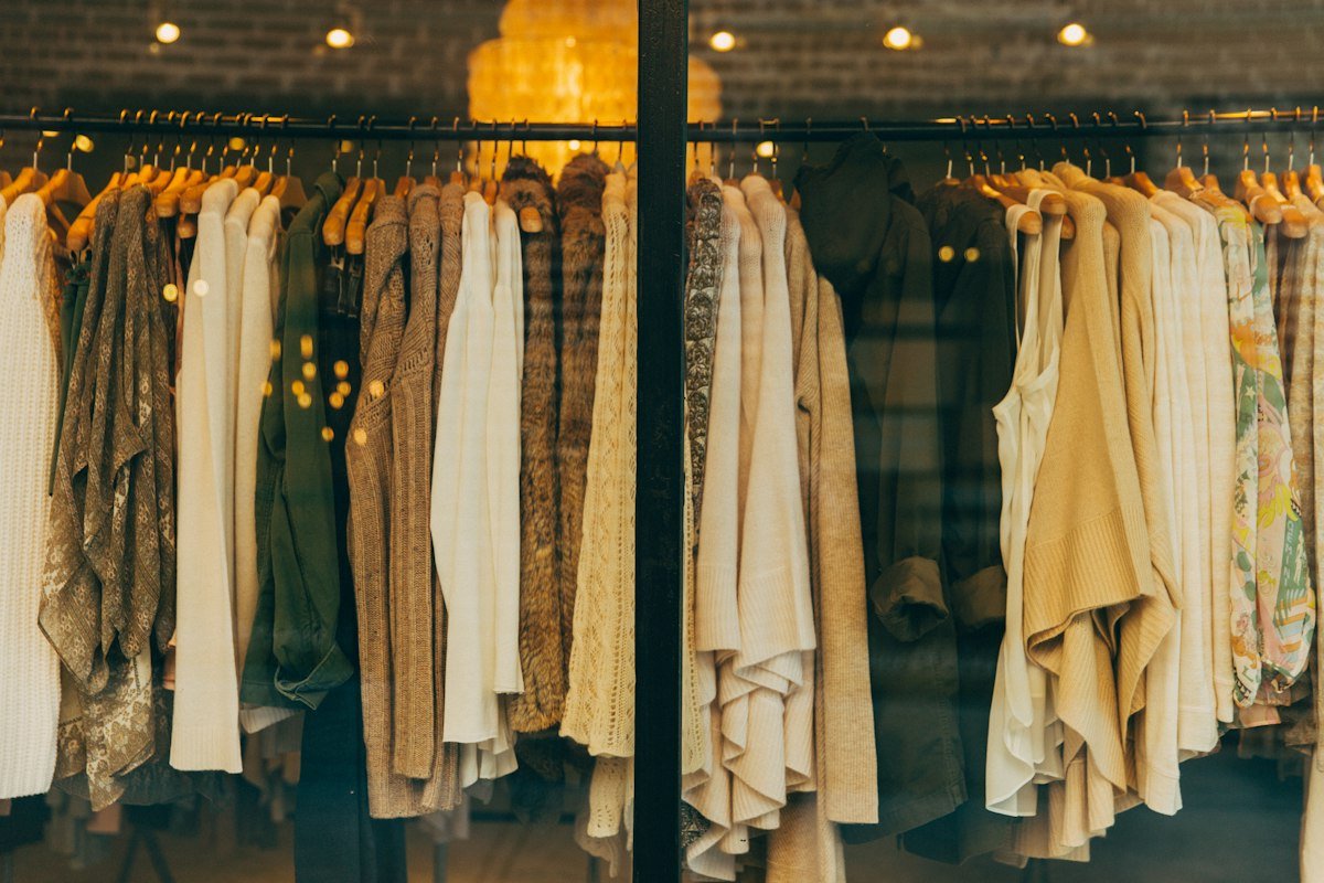 Elegant women's garments in soft neutral tones hanging in-store